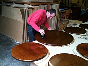 Image of Lee staining some table tops.